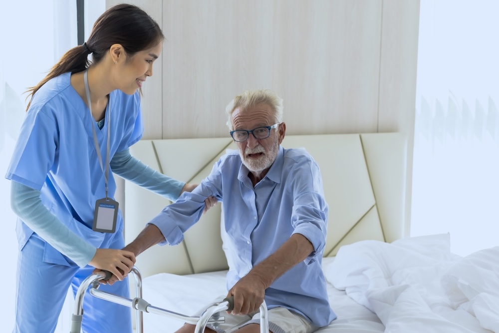 Kind Asian female nurse helping elderly retirement man in nursing home care